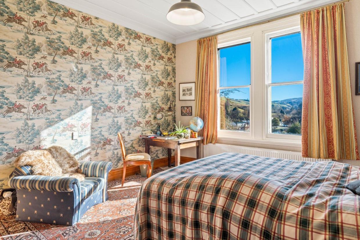 This bedroom has a traditional Sanderson hunting wallpaper. 