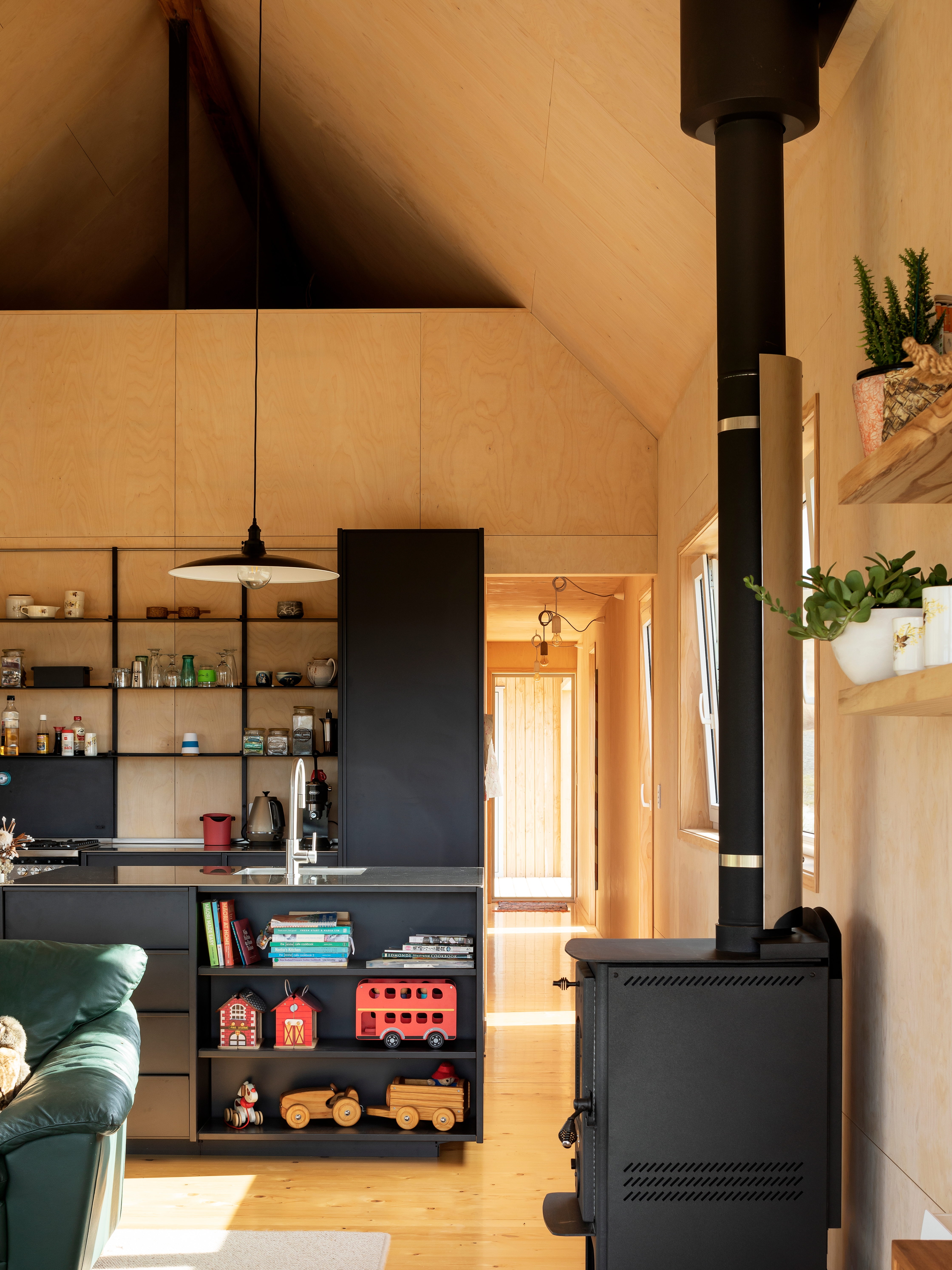 Life here is as relaxed as it might be in an actual tramping hut. “If someone drags in some dirt, no problem, we just sweep it back out,” says Sarah. “If there’s a need to hang wet clothing by the Wagener Leon fire, then that’s fine too.” Sarah says the loft up the top is a boon that “will evolve over time and change as our needs do”. As well as being Sarah’s workspace and Daisy’s playroom, it currently functions as a sewing and music room.