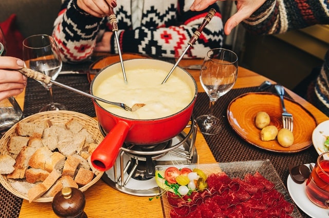  Friends sharing fondue and other nibbles at a low table during winter.