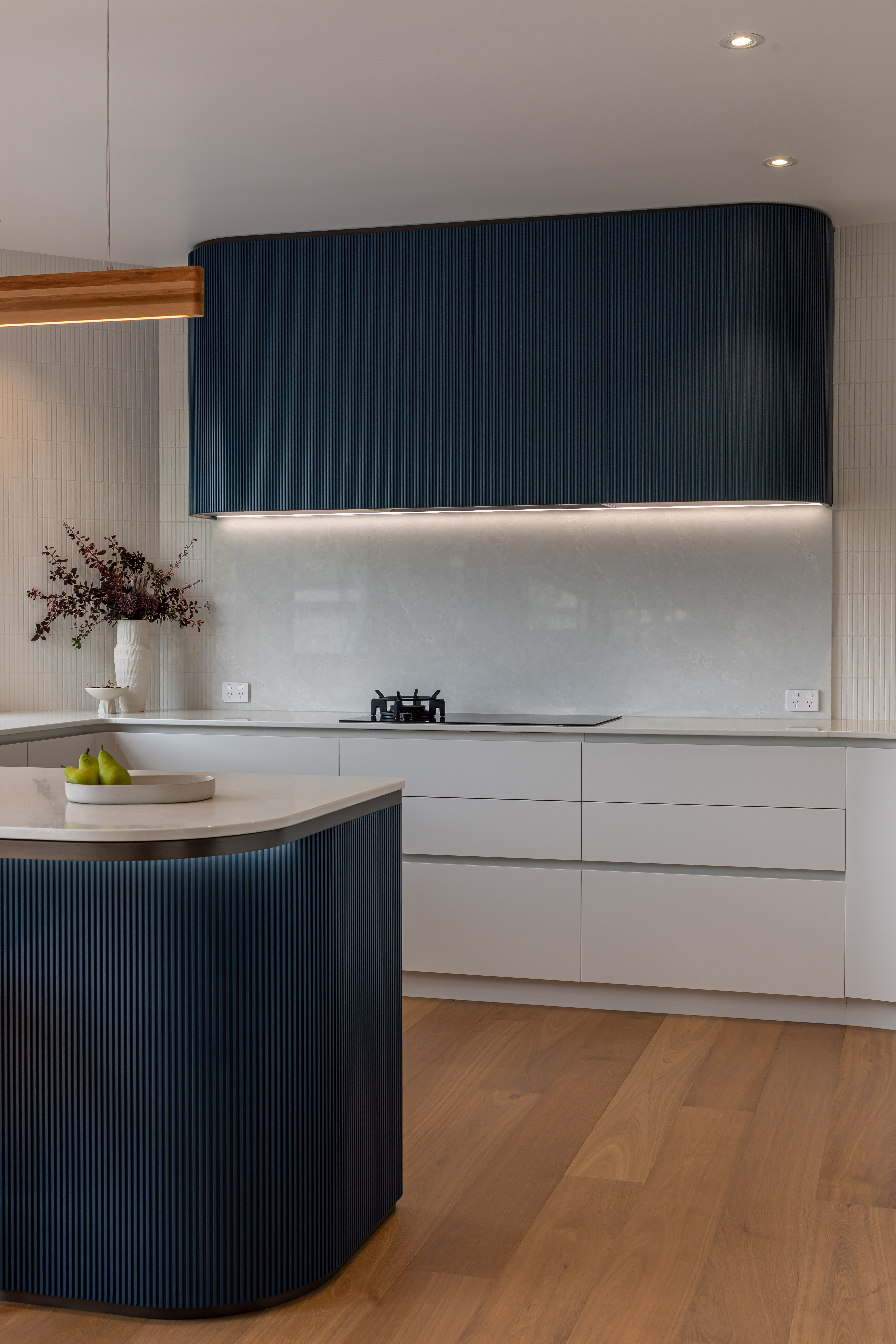 In this Cockle Bay kitchen, designed by MS Studio, a symphony of curves and angles is accentuated by a multi-faceted lighting plan. Image: John Williams