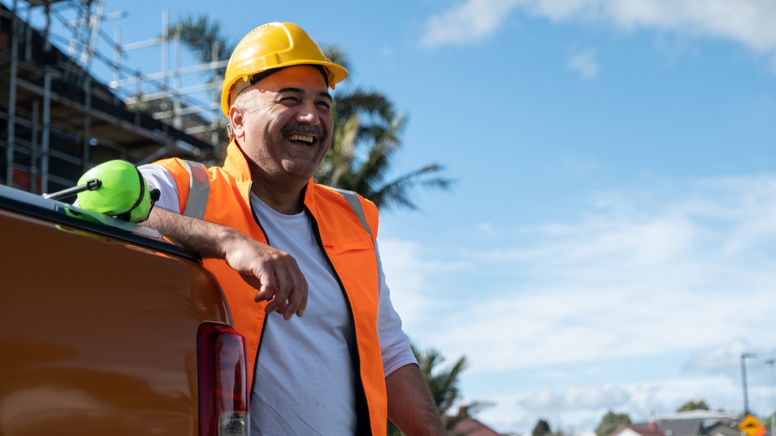 Man in high vis vest on building site smiles