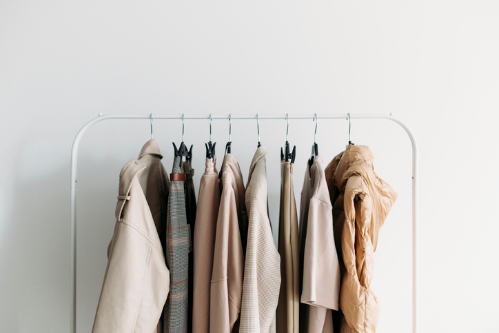 Image showing a clothing rail with a collection of neutral-toned women's clothing in brown and white hues.