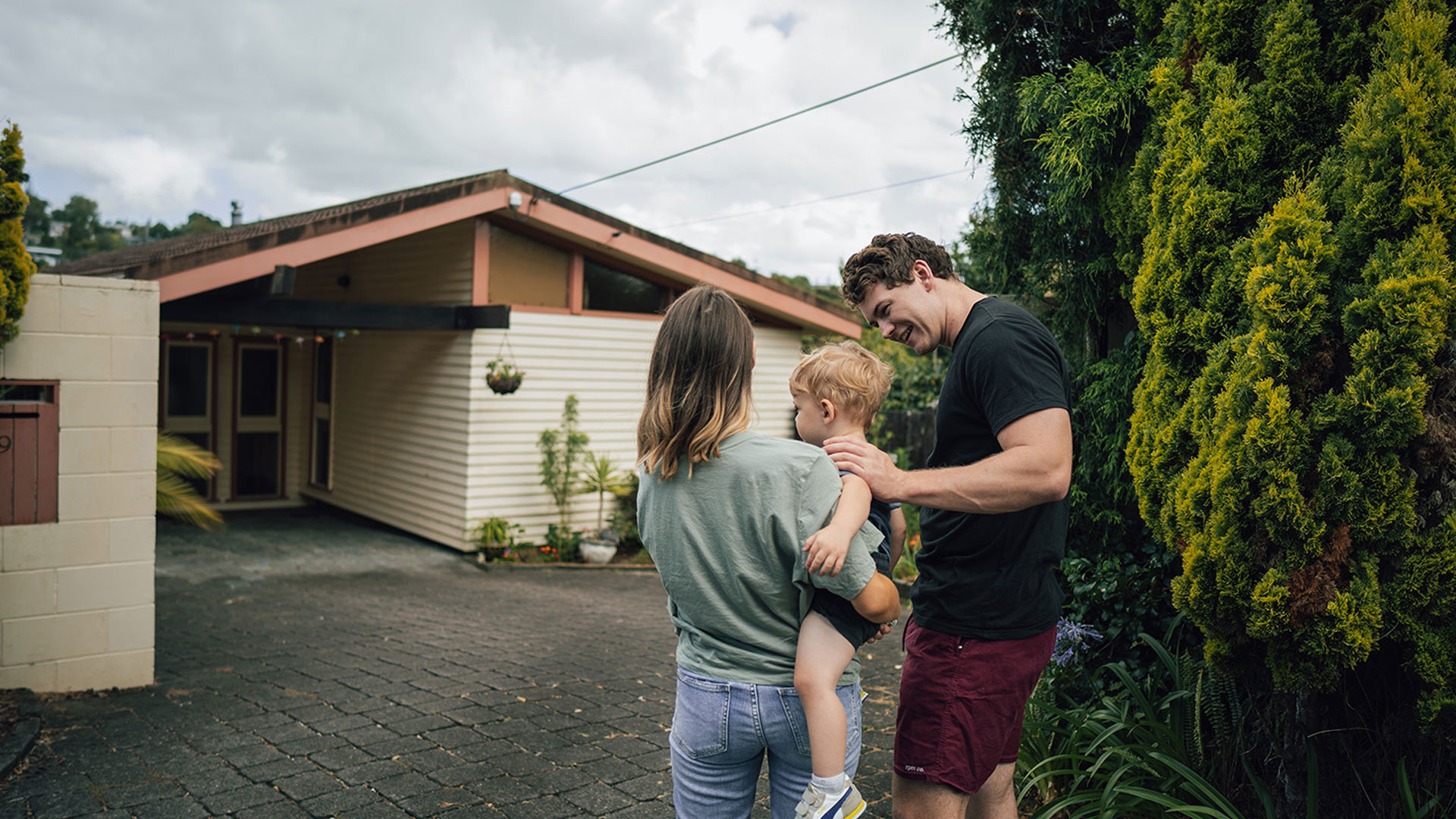 Young couple with a toddler looking at the first home they have bought on Trade Me Property.