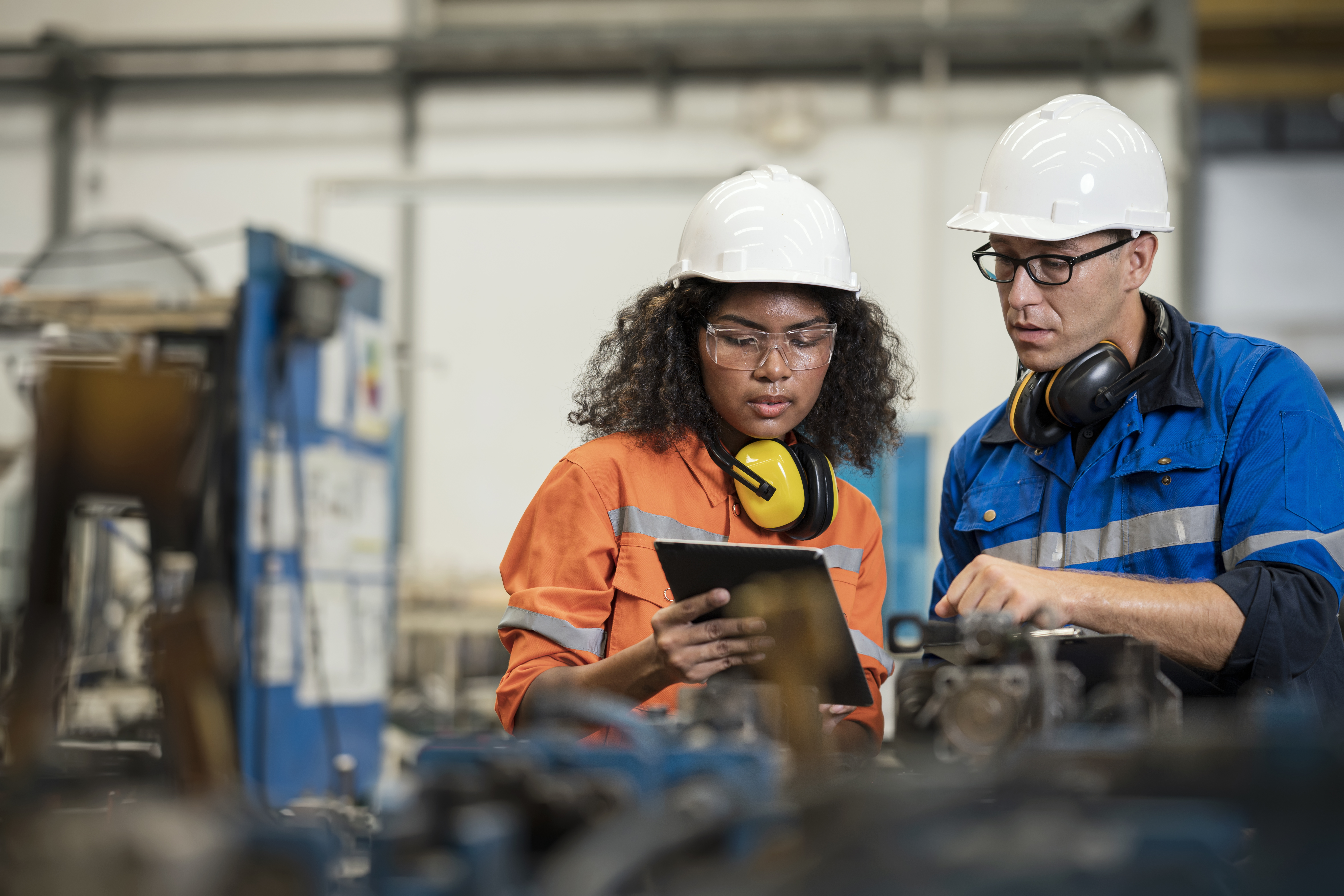 Female and male machine operators working together