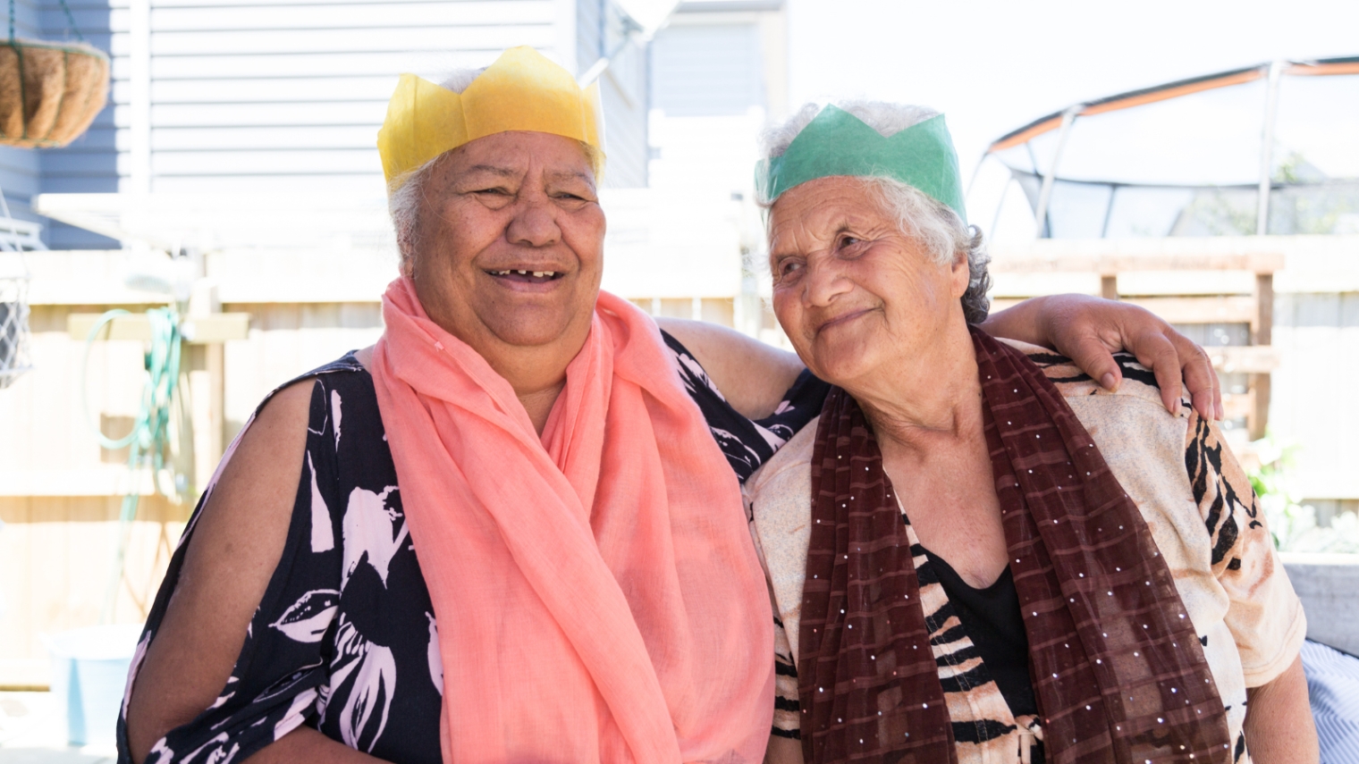 Two elderly ladies with brithday hats on. 
