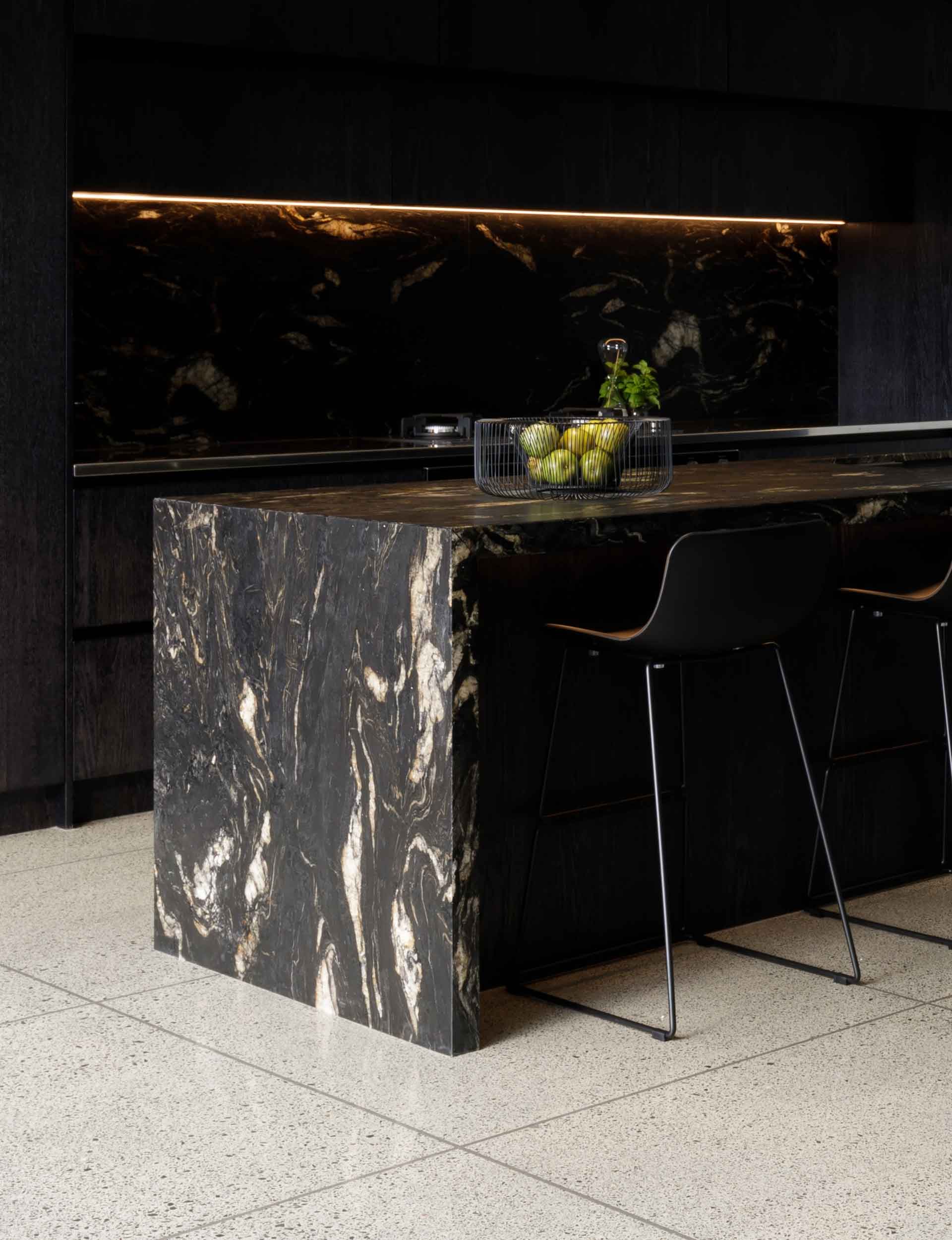 close up on black marble kitchen counter and fruit bowl