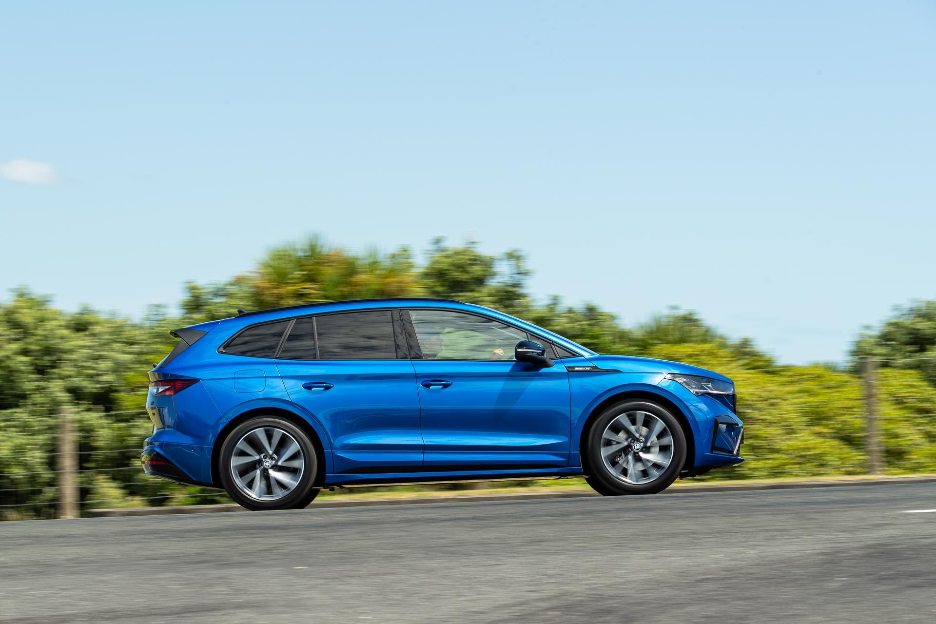 Blue Skoda Enyaq Sportline action shot from the side