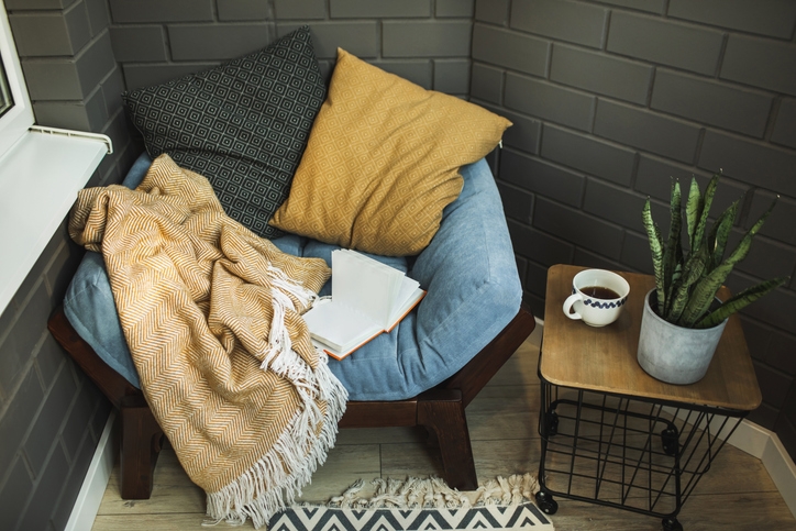 A cozy nook with soft cushions and a warm blanket perfect for relaxing and reading.