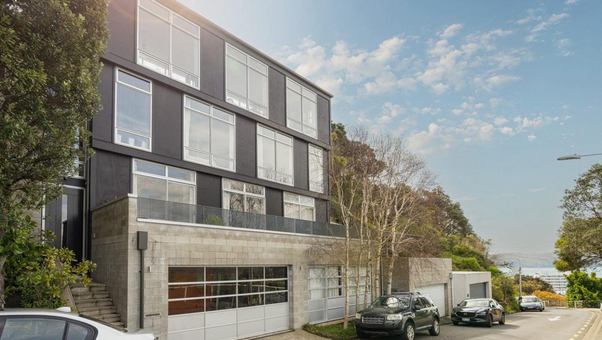 Designed by architect Nicolas Stevens of Stevens Lawson Architects, the house has a “fire station” door for the garaging. The other space at ground level is a workshop. Photo: Lowe & Co