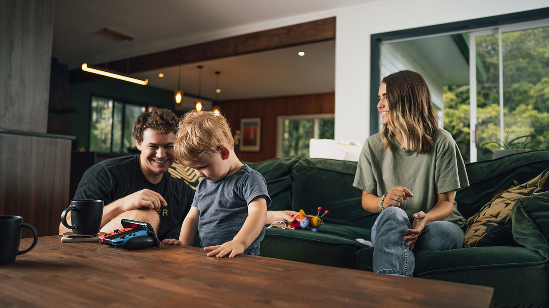 Young parents playing with their child in the living room of their New Zealand home.