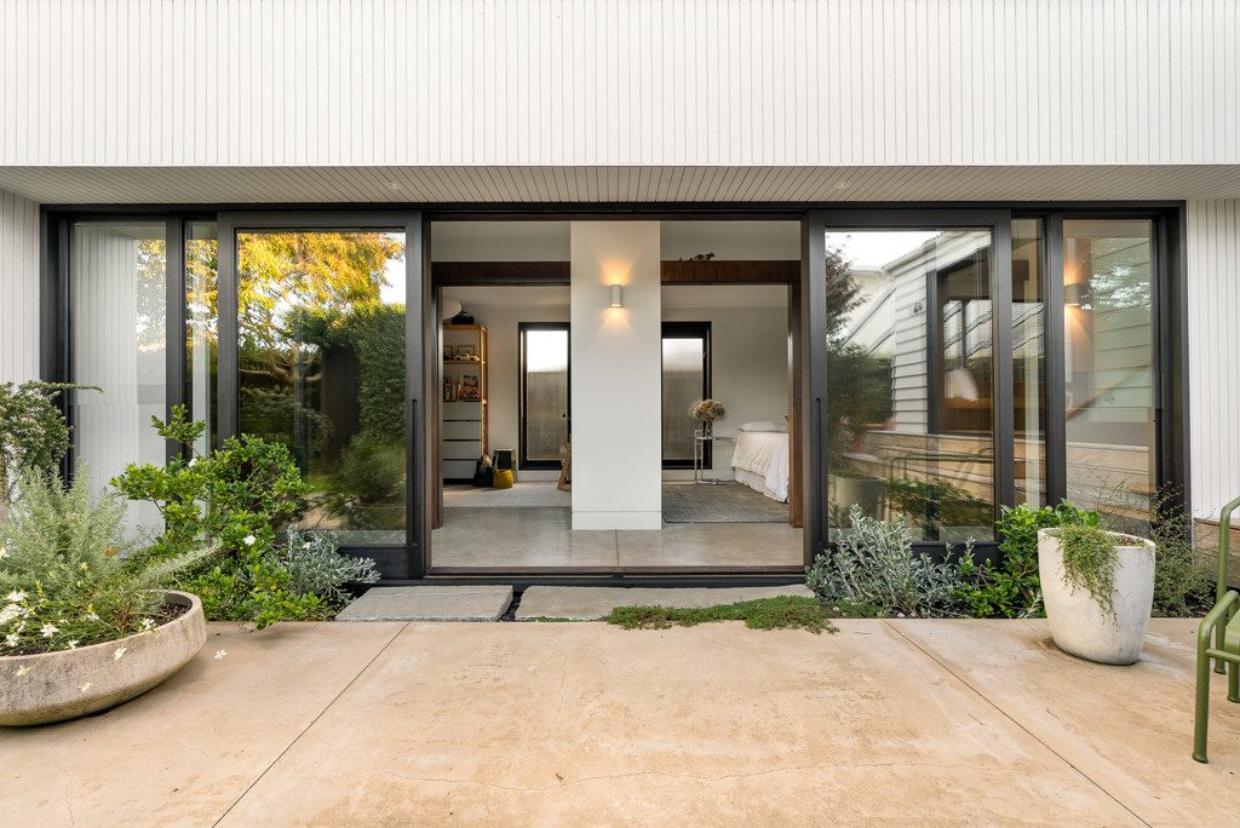 Wide glass sliding doors opening out to the backyard