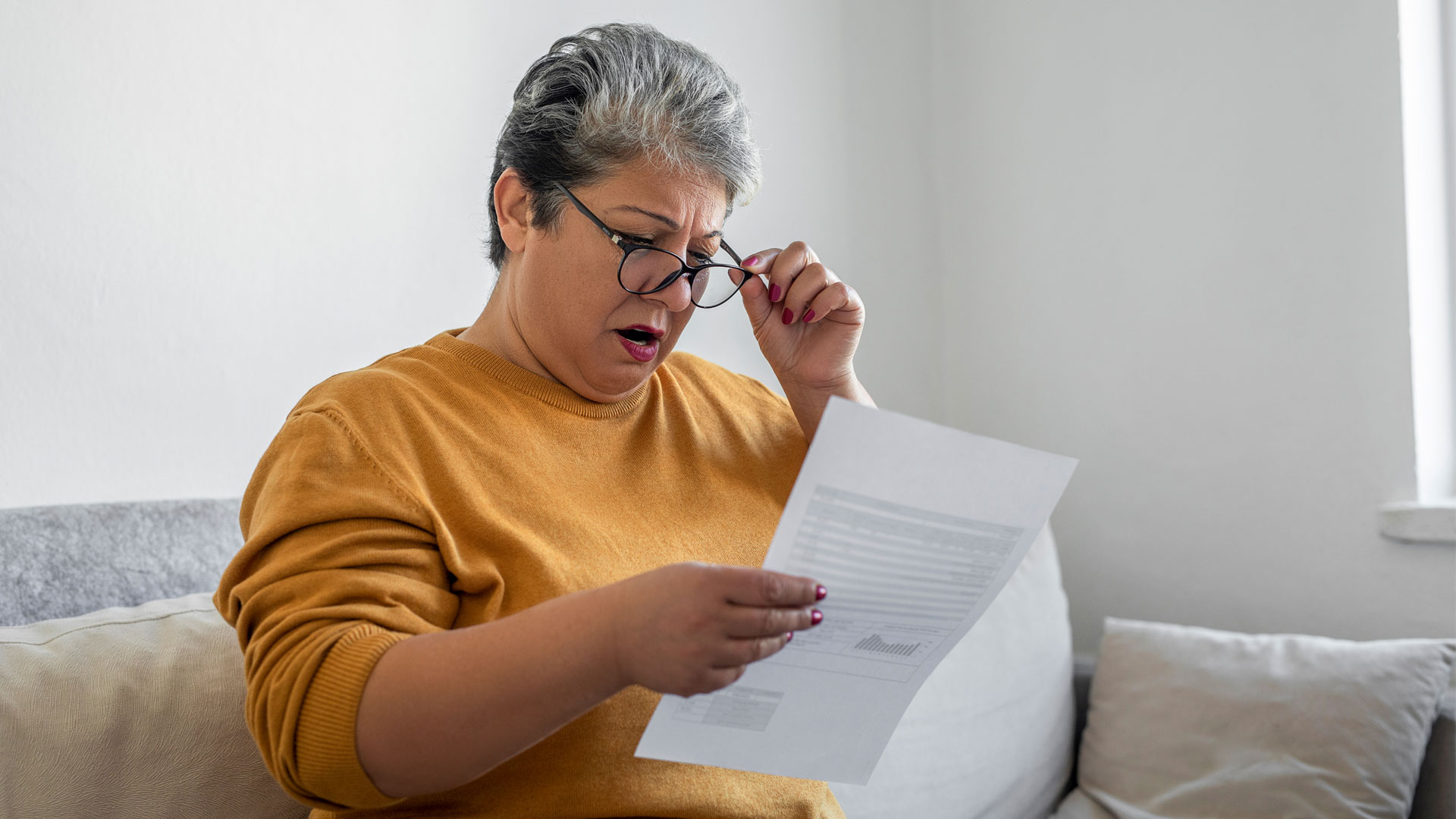 Surprised landlord reading a letter detailing a fine for non-compliance.