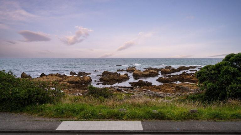 The house looks directly out to sea on the Island Bay waterfront, and is protected from surge tides by a rocky outcrop. Photo: Lowe & Co
