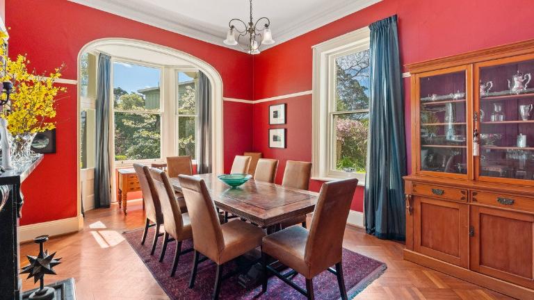 Bright red walls create a convivial ambiance for the formal dining room. Photo: Columbs & Co