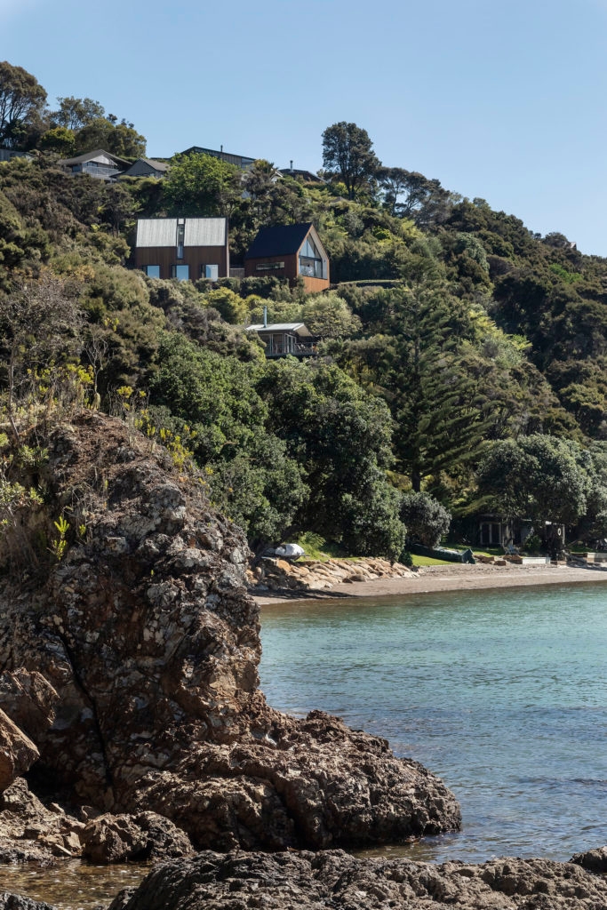 A view of a large cliff-top home from the bay below.