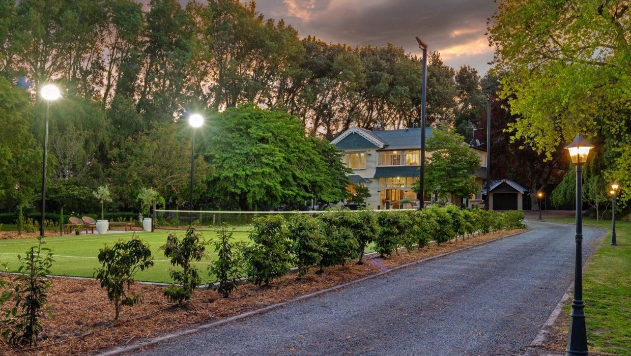 The driveway is lit by carriage lamps