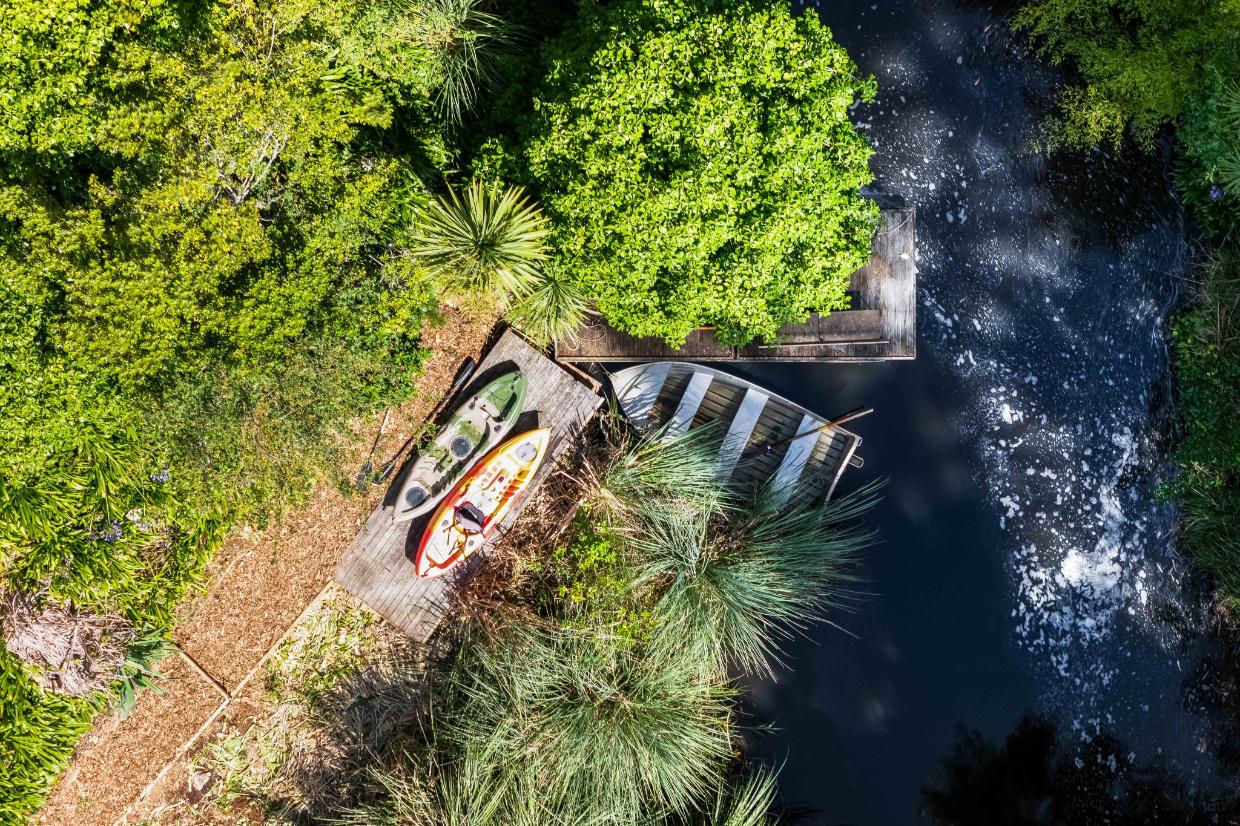 The home has a floating dock at the bottom of the garden. 