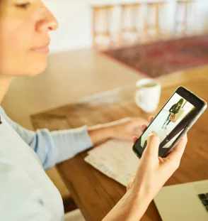 Woman sitting inside looking at live camera image on phone