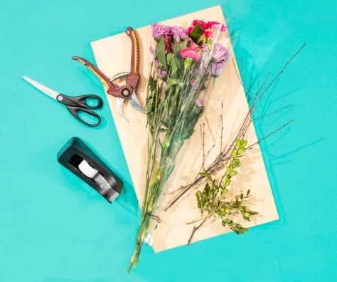 Scissors with Flowers and Tape on a Cutting Board