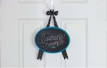 chalkboard door sign hanging on a white door