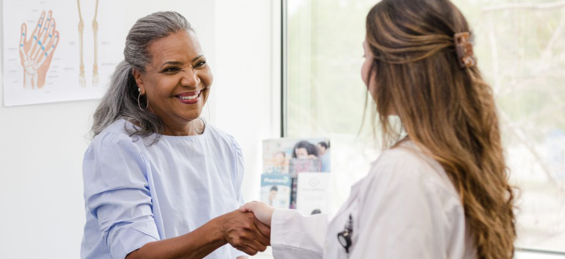 Older woman at the doctor's office shaking hands with doctor