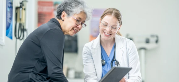 Older woman looking at medical chart with doctor