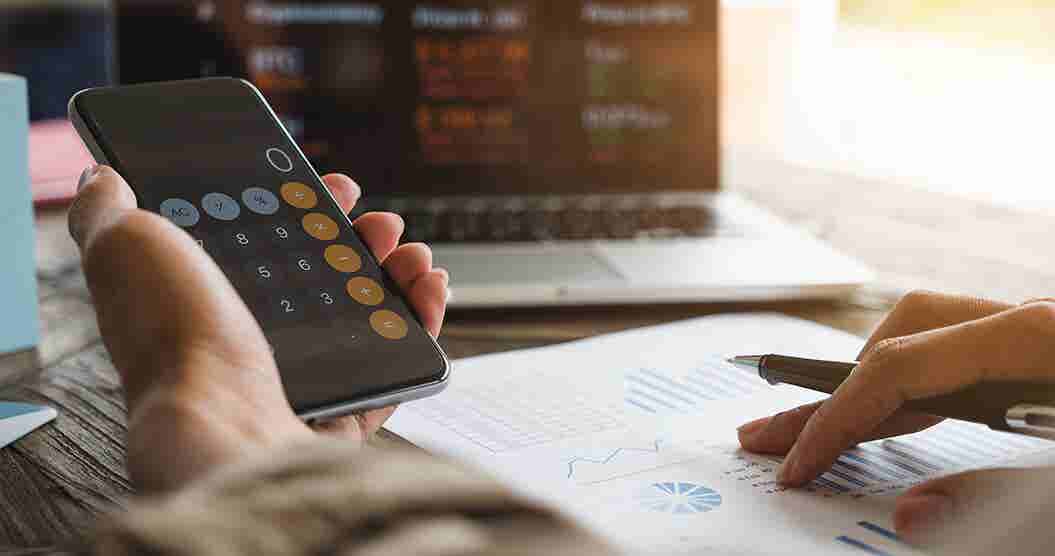 Person at desk holding calculator