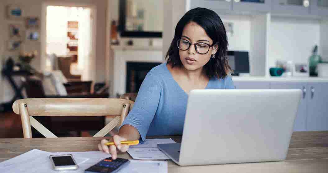 Young woman using her laptop to create a budget