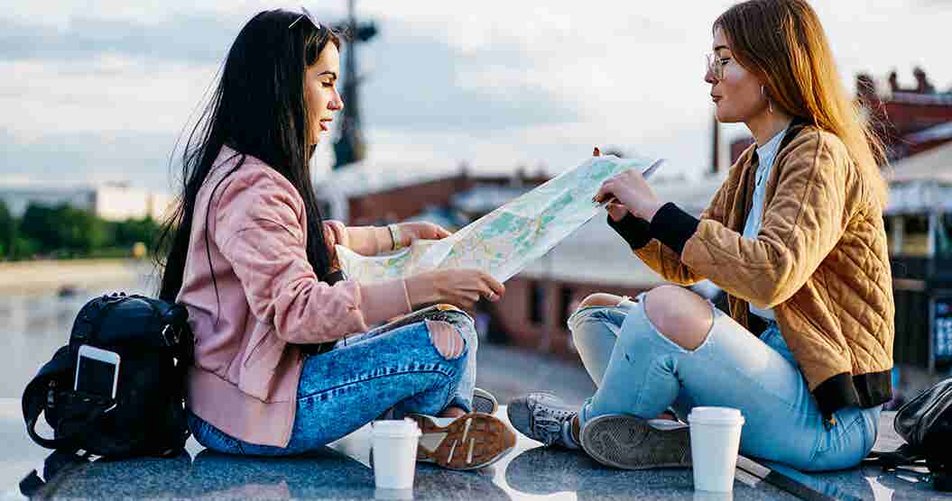 Two travelers using a map to plan their trip.