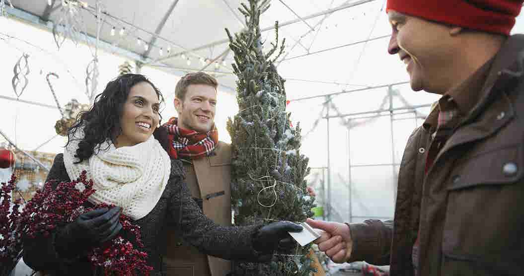 Couple using a credit card to pay for a Christmas tree