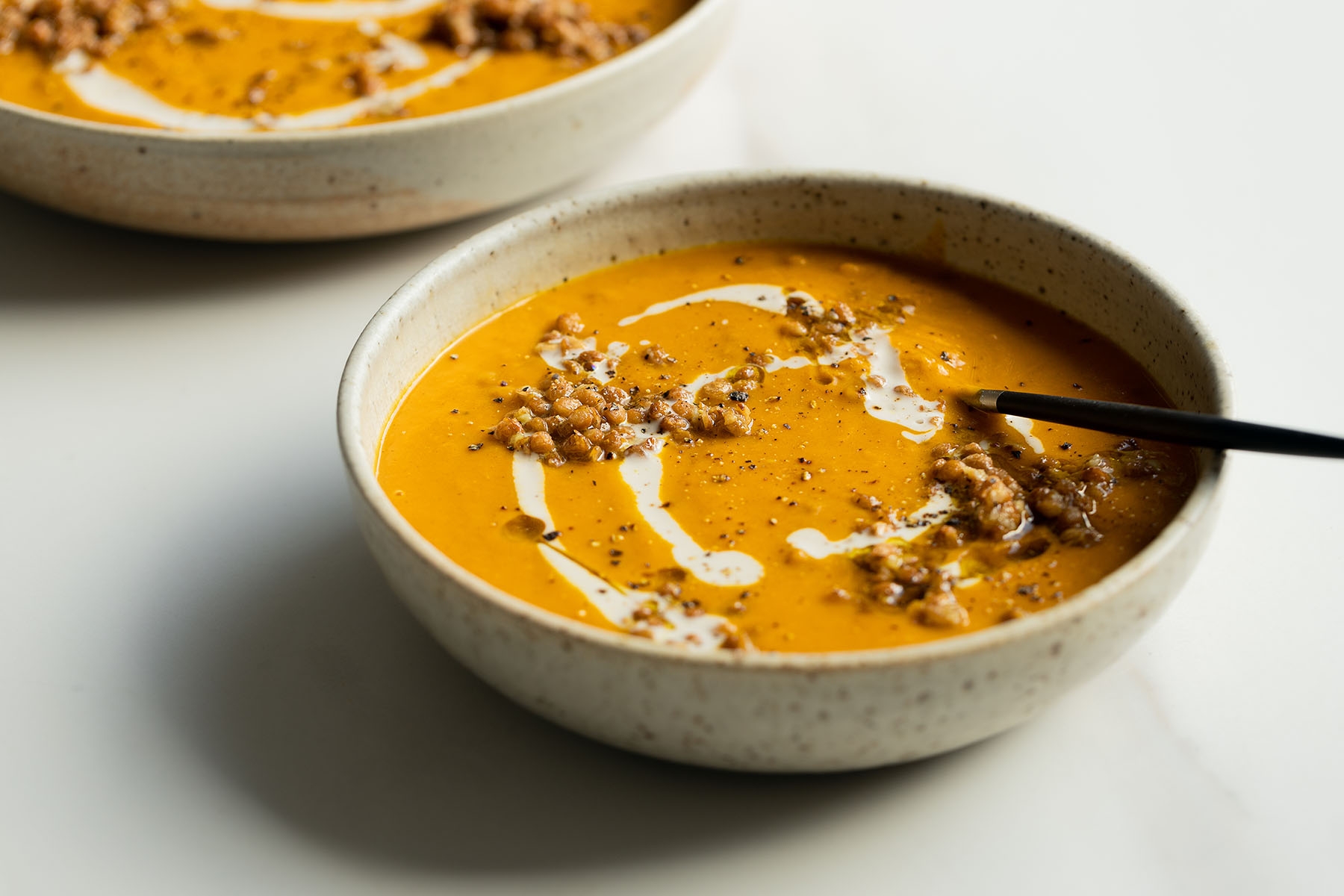 Pumpkin, kumara and lentil soup topped with garlicky olive oil lentils