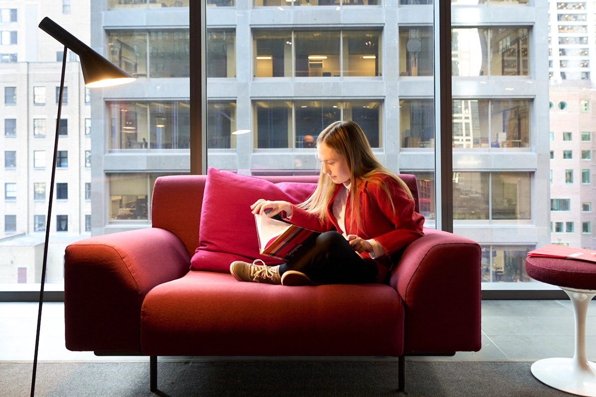Employee reading on a chair at the Chicago Morningstar office.