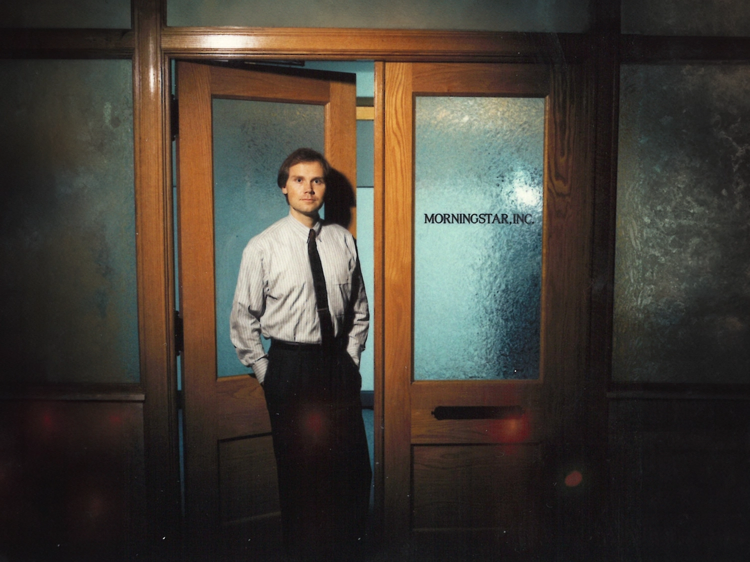 Joe Mansueto standing in front of doors representing the beginning of Morningstar.