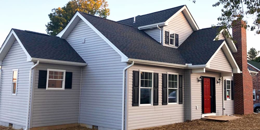 Exterior view of updated home with gray siding and white vinyl double-hung windows