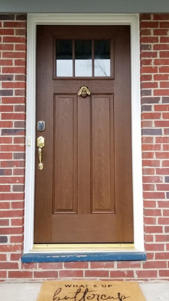Wood-look fiberglass two-panel 1/4 light entry door on a brick home