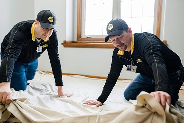Pella window installers lay down a sheet for easy clean-up after window replacement