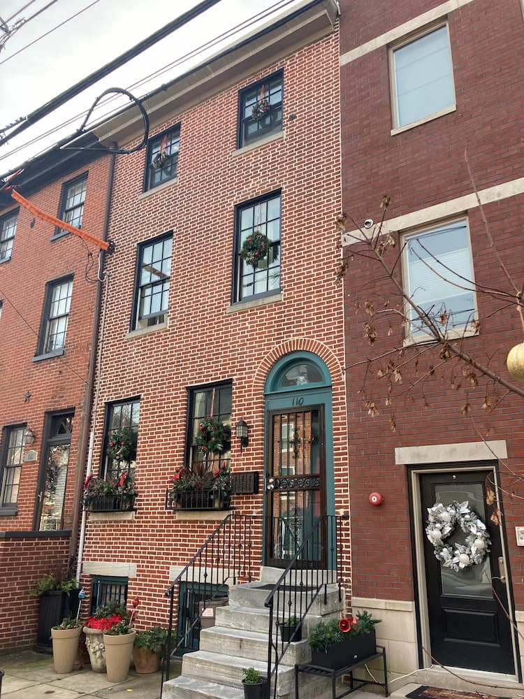 Street view from the right of brick historic building featuring new black wood double-hung windows