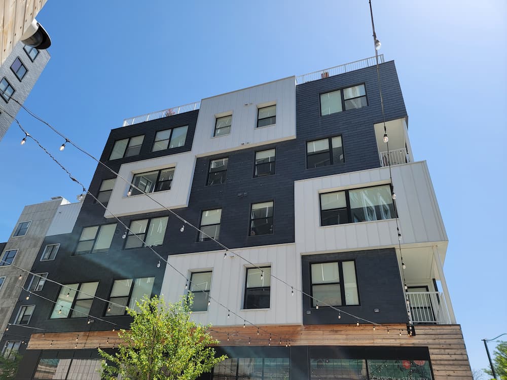 Black and white checkerboard apartment building featuring black fiberglass single-hung windows