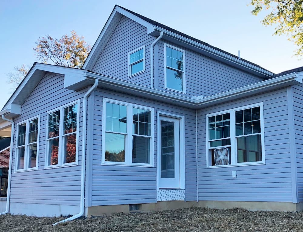 Exterior view of updated home with siding and white vinyl double-hung windows