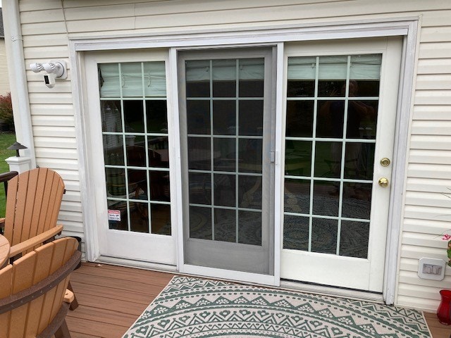 Old, white traditional-styled porch doors with grilles