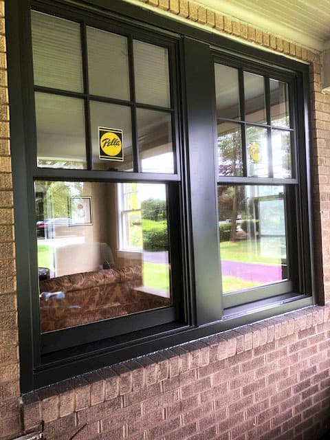 New wood black double-hung windows with traditional grille pattern on the upper sash