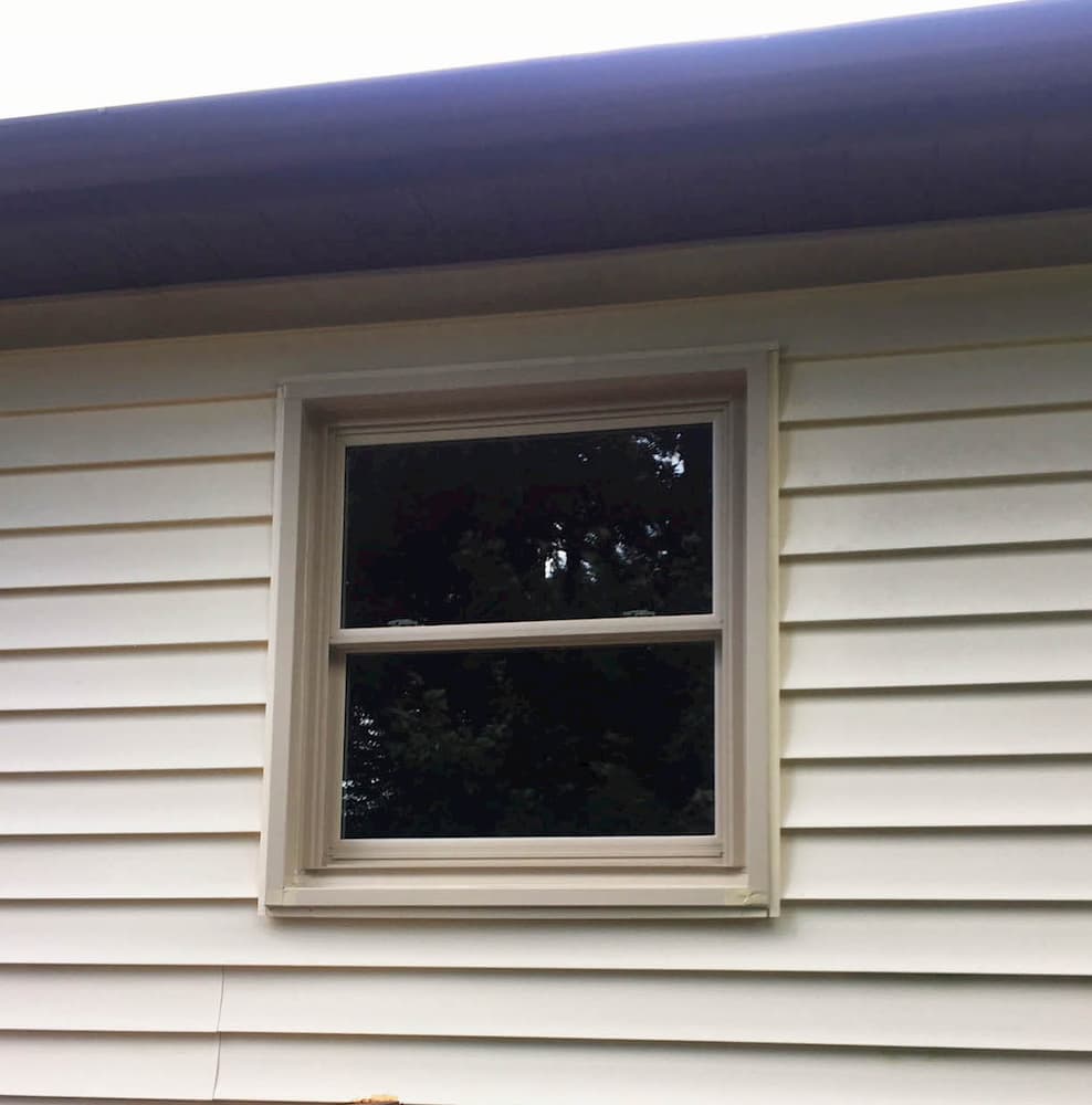 New vinyl double-hung window on home with beige siding