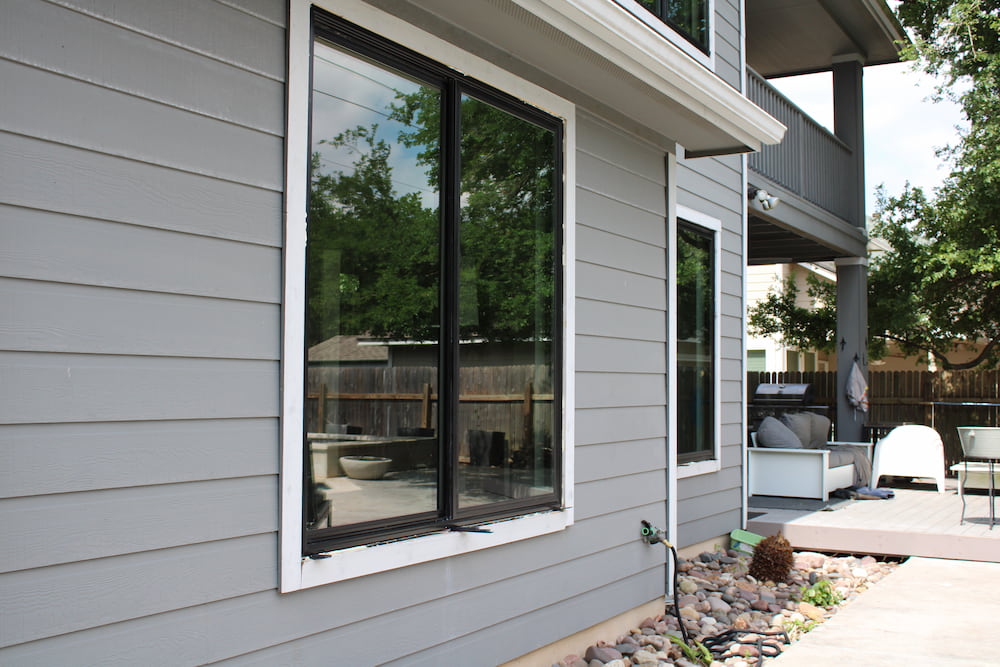 Close up image of back of Austin home with new Pella Impervia fiberglass sliding windows