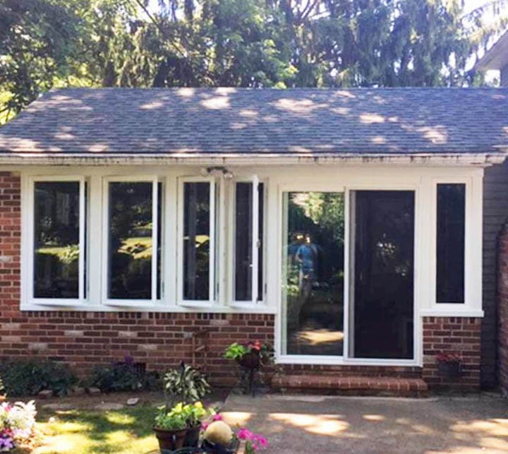 Exterior view of brick porch with new vinyl casement windows and sliding patio door