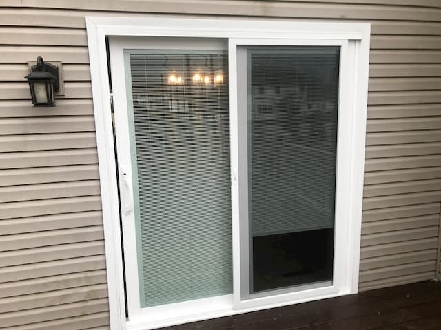 Exterior view of replacement 250 Series vinyl sliding patio door with white trim, built-in blinds