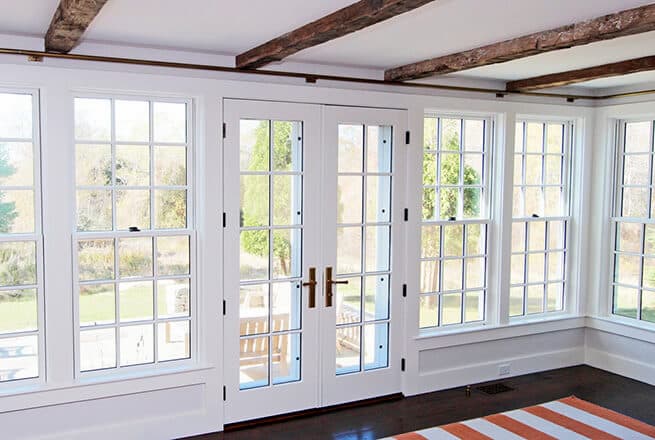 Interior view of wood double-hung windows and double hinged French patio doors