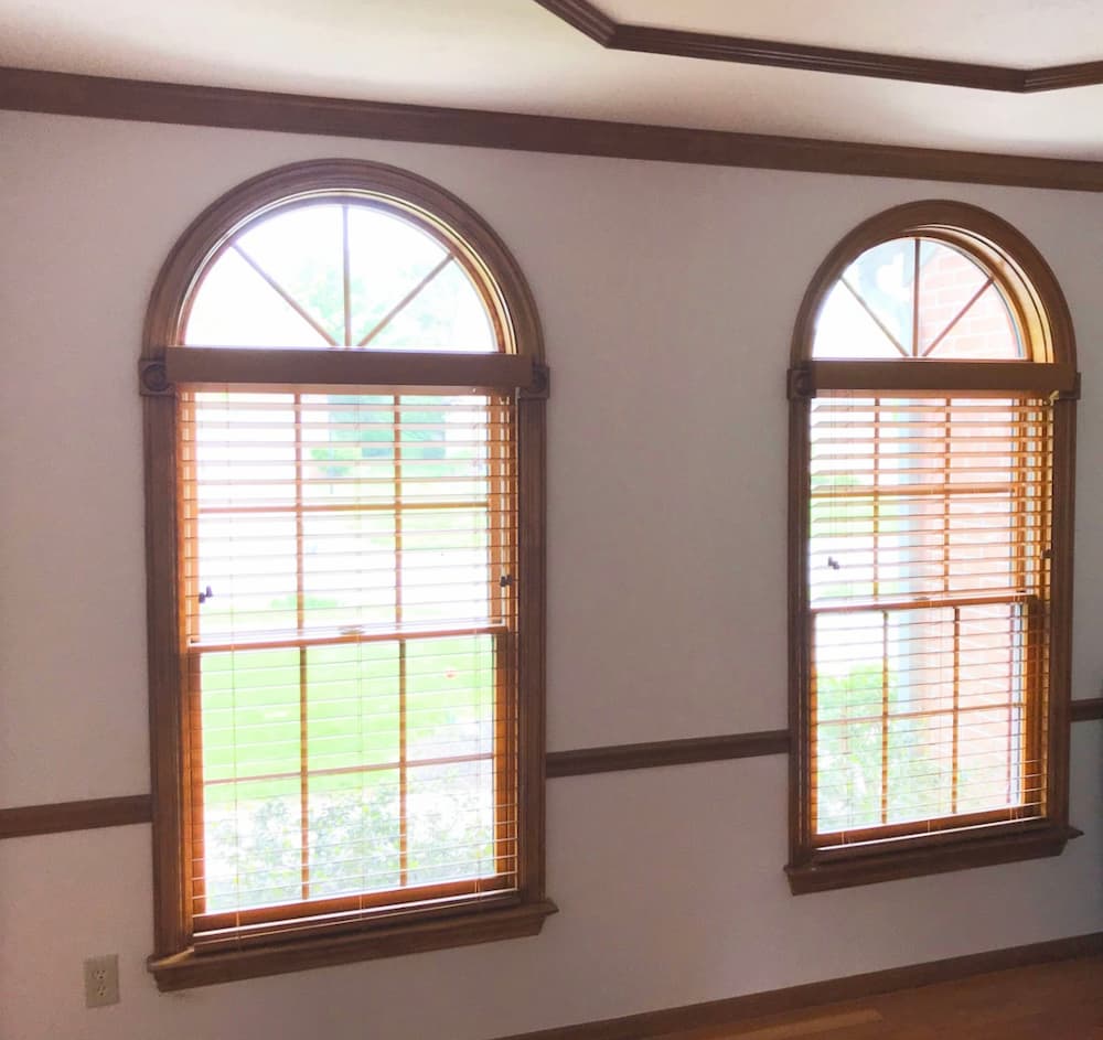 Two wood double-hung windows with half-circle transoms