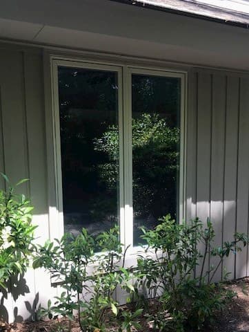 Twin wood casement windows with a garden view