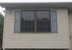 Exterior view of two new wood double-hung windows with traditional grille pattern