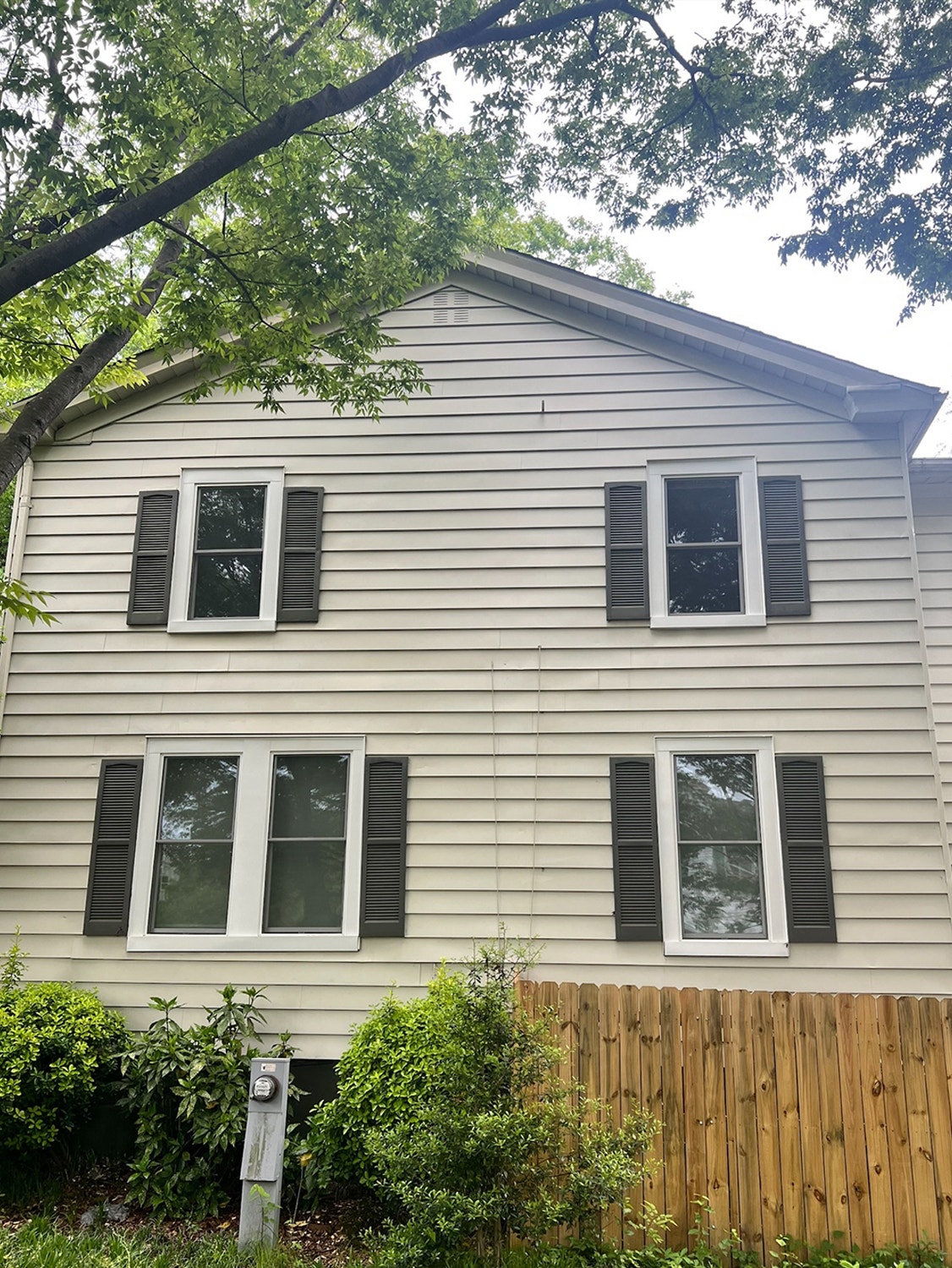 Double-hung windows with dark shutters on Portsmouth home